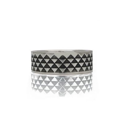 Silver ring with oxidised triangle pattern lying flat on a white background