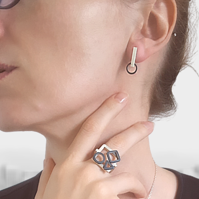 Handmade Minimalist Patina Stud Earrings in Sterling Silver is shown on a white lady.