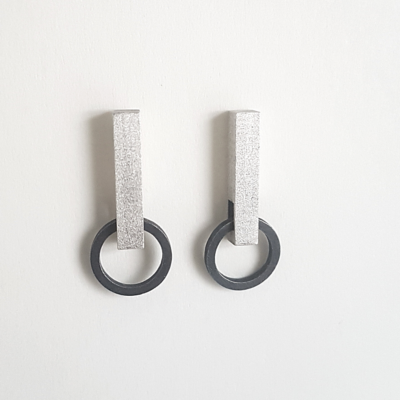 Hand-carved Minimalist Silver Patina Stud Earrings is shown on the white holder.