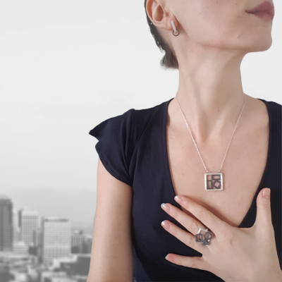 Artisan Geometric Patina Sterling Silver Set (a ring and a pendant) is worn on the lady.