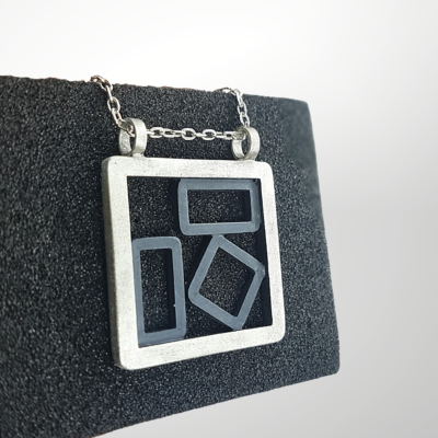 Hand-carved Patina Silver Pendant Necklace is displayed on the black sponge.