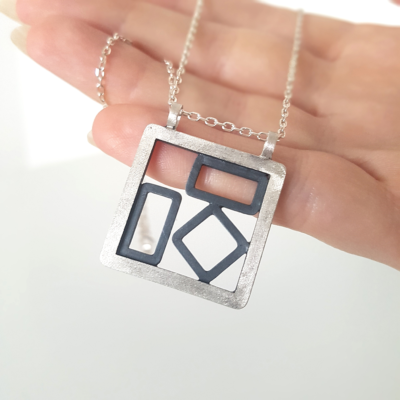 Artisan Custom Patina 925 Silver Pendant Necklace is hanging on the palm.