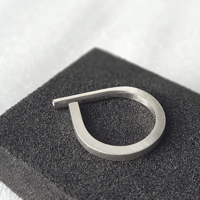 Square Open ended ring in sterling silver with crimson garnet is placed on the black sponge.