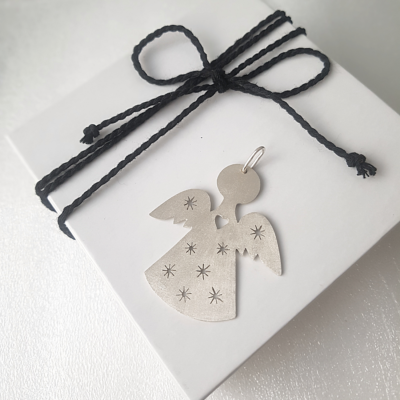 Unique Silver Angel Christmas decoration on a white gift fox tied with black cotton string.